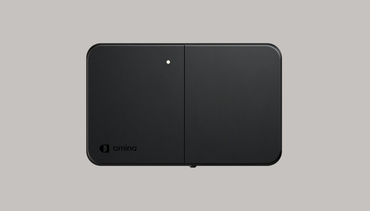 amina 1 home EV charger in horizontal orientation on neutral grey background, highlighting compact form, integrated LED indicator and minimalist Scandinavian design for residential installations.