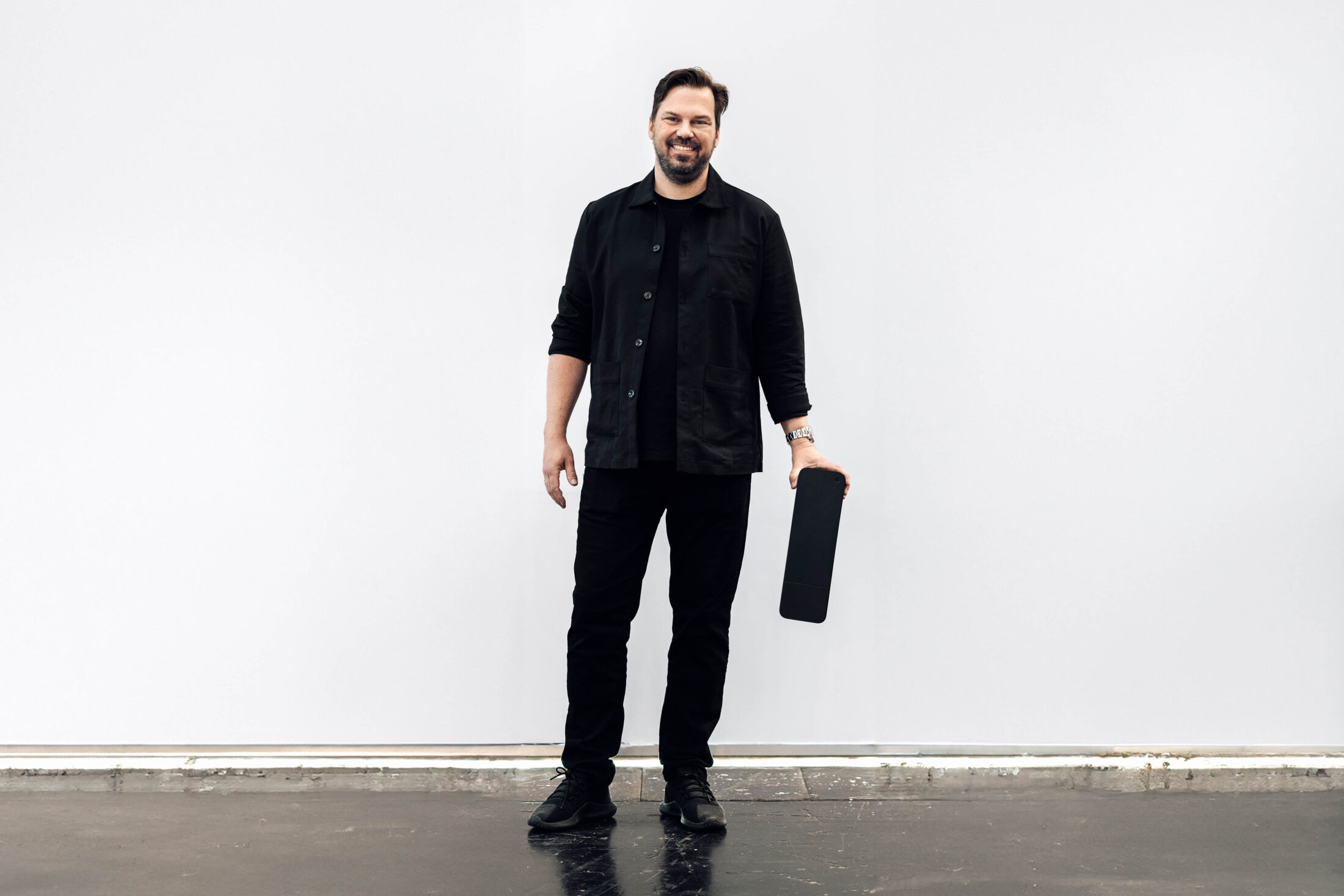 Jone Fredriksen, Product Manager at amina, holding an amina EV charger, highlighting product development and hardware expertise behind scalable charging solutions.