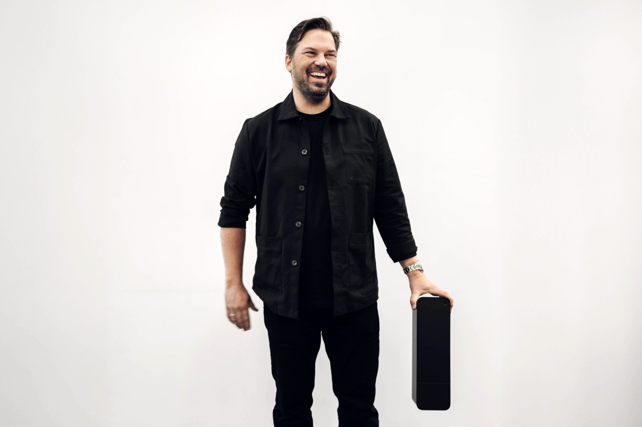 Jone Fredriksen, Product Manager at amina, holding an amina EV charger, highlighting product development and hardware expertise behind scalable charging solutions.