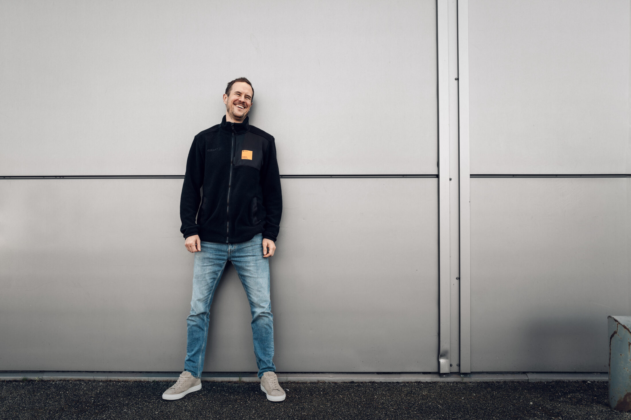 Product manager at amina wearing navy jacket and orange badge