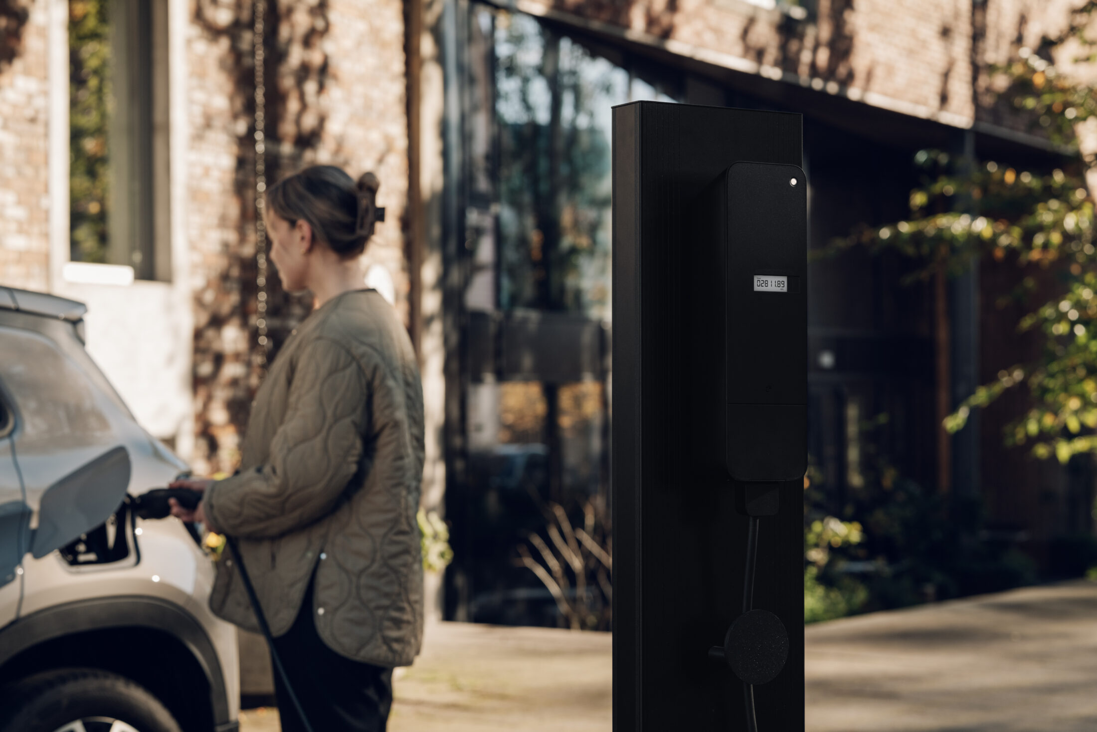 Woman charging electric vehicle with amina M MID-certified EV charger Netherlands